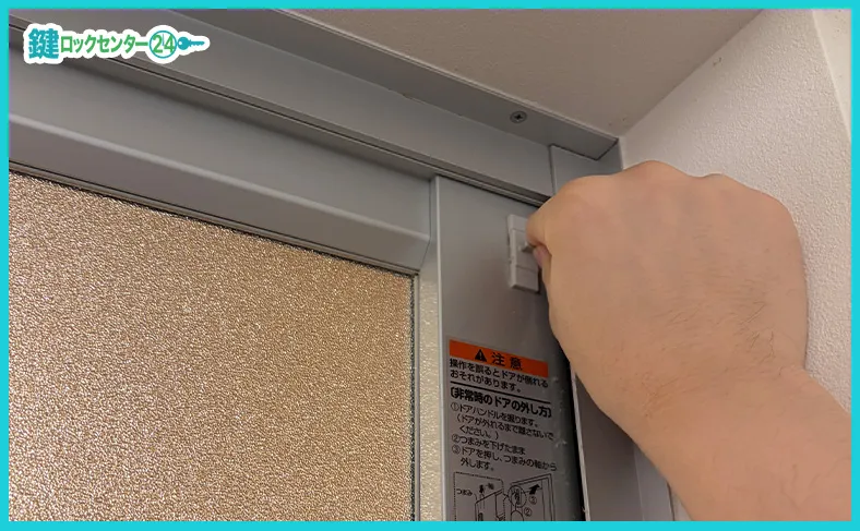 ドア上部に付いているツマミを使って浴室ドアを外す