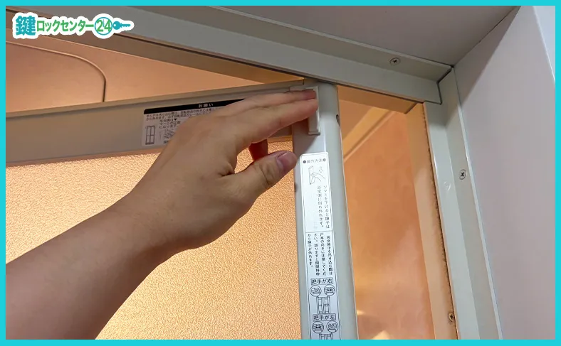 ドア上部に付いているツマミを使って浴室ドアを外す